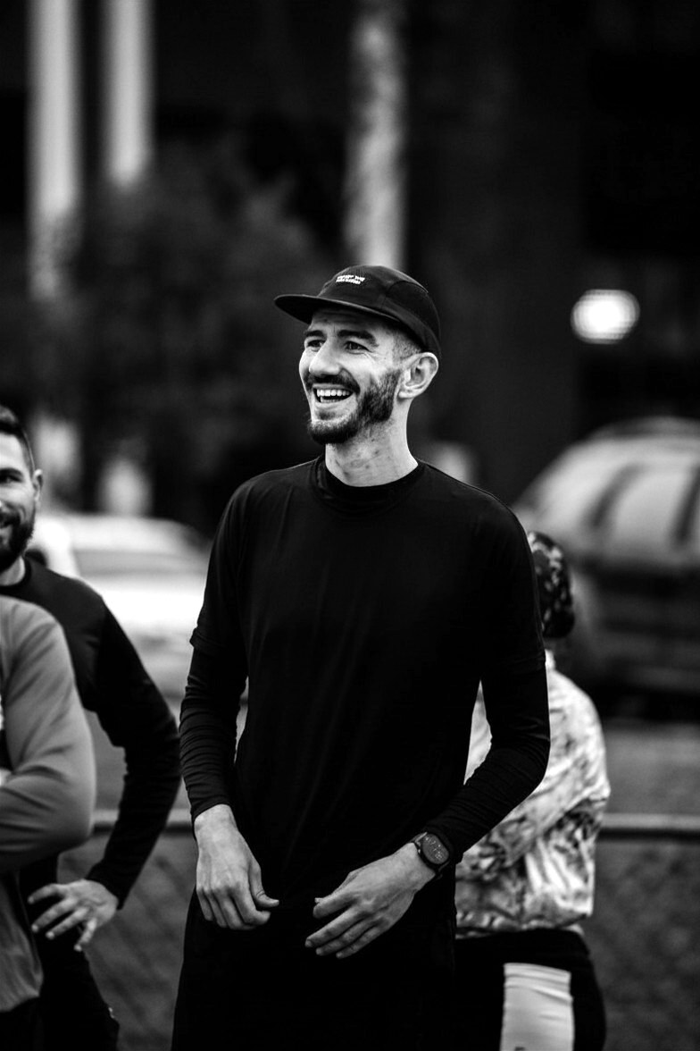 Atleta sorrindo entre amigos com boné STORM