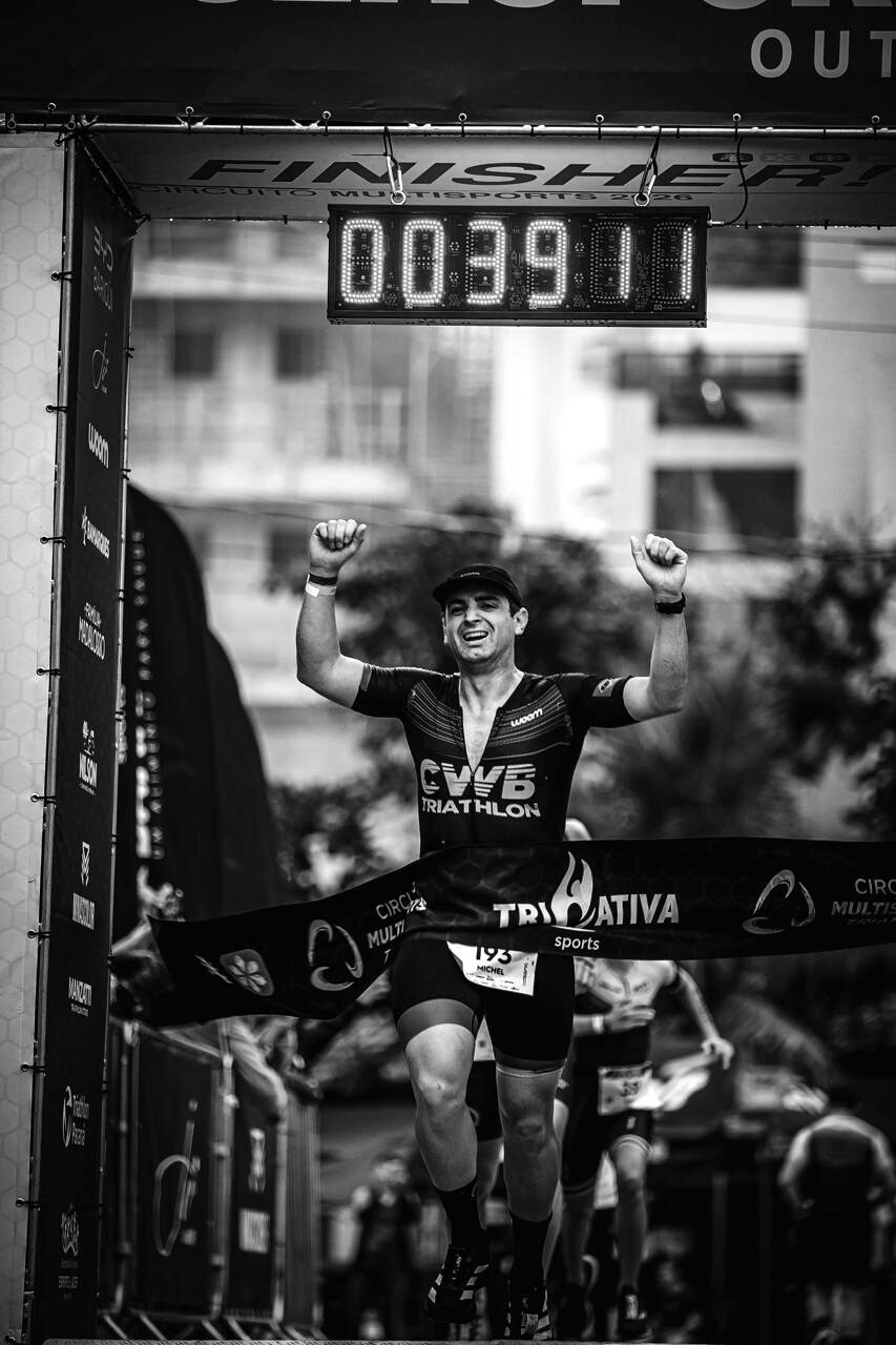 Triatleta comemorando uma chegada com boné STORM